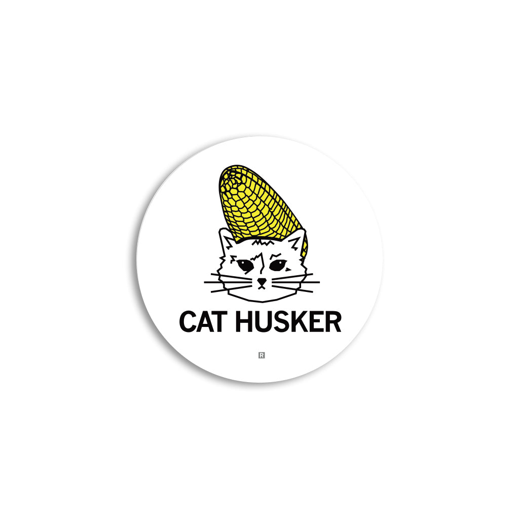 Round vinyl sticker featuring a line-drawing of a cat wearing a corn cob like a hat, with the text CAT HUSKER below.