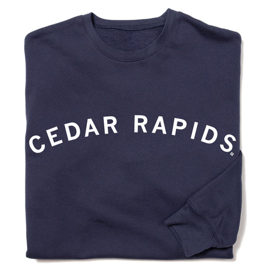 Navy blue RAYGUN crewneck sweatshirt with CEDAR RAPIDS printed in a white, arched font.