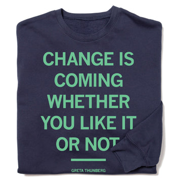 A navy blue, union-made Greta Thunberg crewneck sweatshirt with the text CHANGE IS COMING WHETHER YOU LIKE IT OR NOT in light green, with the activist’s name printed in smaller text below a horizontal line.