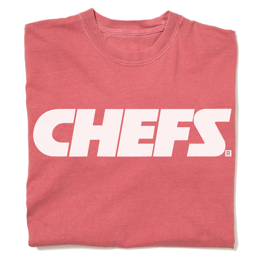 Folded red, union-made heavyweight t-shirt with the word CHEFS printed in large white block letters across the chest.