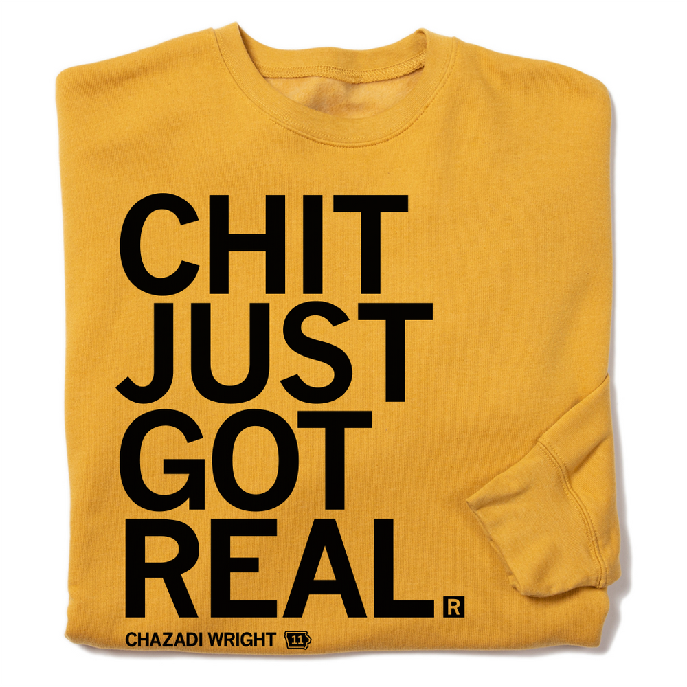 A folded heather yellow sweatshirt with left aligned black ink that reads "Chit Just Got Real. Chazadi Wright 11"