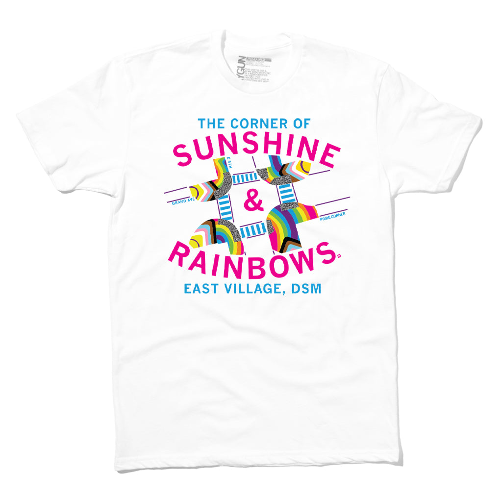 White Pride t-shirt with a graphic of a street intersection labeled The Corner of Sunshine & Rainbows and East Village, DSM, featuring colorful rainbow-themed street signage.