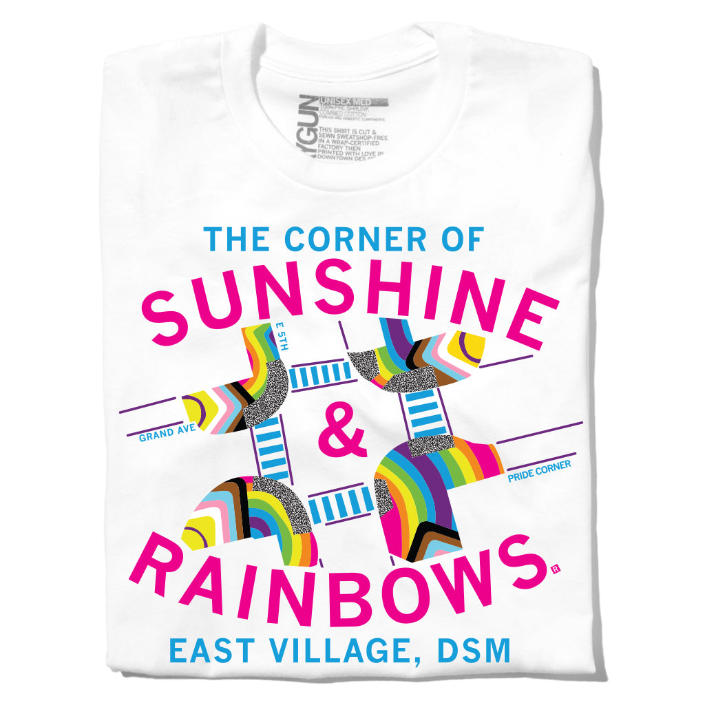 Union-made white t-shirt featuring a graphic that reads The Corner of Sunshine & Rainbows, East Village, DSM, with colorful, patterned illustrations of street signs and crosswalks in this Des Moines Pride design.