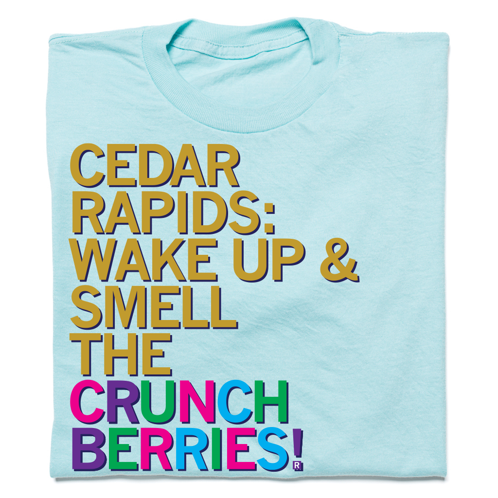 Heather Purist Blue t-shirt featuring the text CEDAR RAPIDS: WAKE UP & SMELL THE CRUNCH BERRIES! printed in multi-colored block letters.