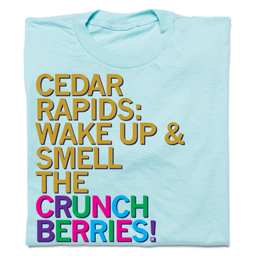 Heather Purist Blue t-shirt featuring the text CEDAR RAPIDS: WAKE UP & SMELL THE CRUNCH BERRIES! printed in multi-colored block letters.