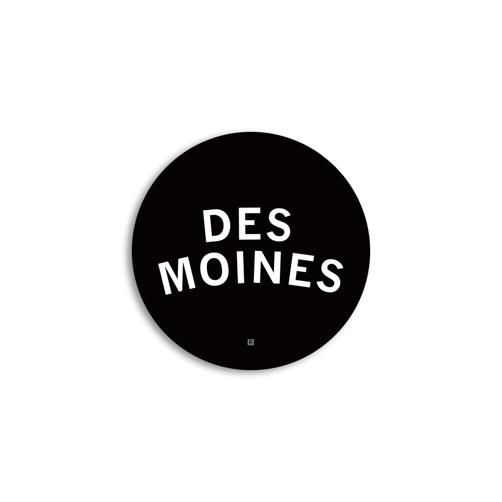 Black circular Des Moines logo with the words in white sans-serif capital letters on a vinyl sticker.