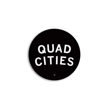 A round black RAYGUN vinyl sticker with the white text QUAD CITIES and a small R symbol at the bottom.
