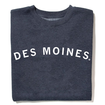 A charcoal grey RAYGUN crewneck sweatshirt with the text DES MOINES printed in white across the chest.