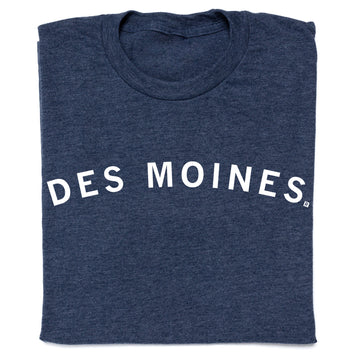 A folded navy blue RAYGUN T-shirt with the text DES MOINES printed in white across the chest.