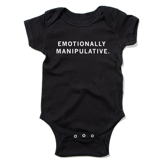 Black union-made baby bodysuit by RAYGUN, featuring the text EMOTIONALLY MANIPULATIVE. printed in white on the chest.