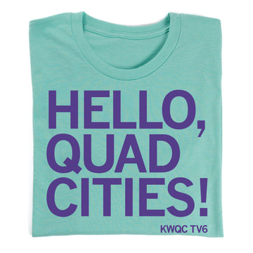 A teal Paula Sands Live t-shirt featuring the purple text HELLO, QUAD CITIES! with KWQC TV6 printed in the bottom right corner.
