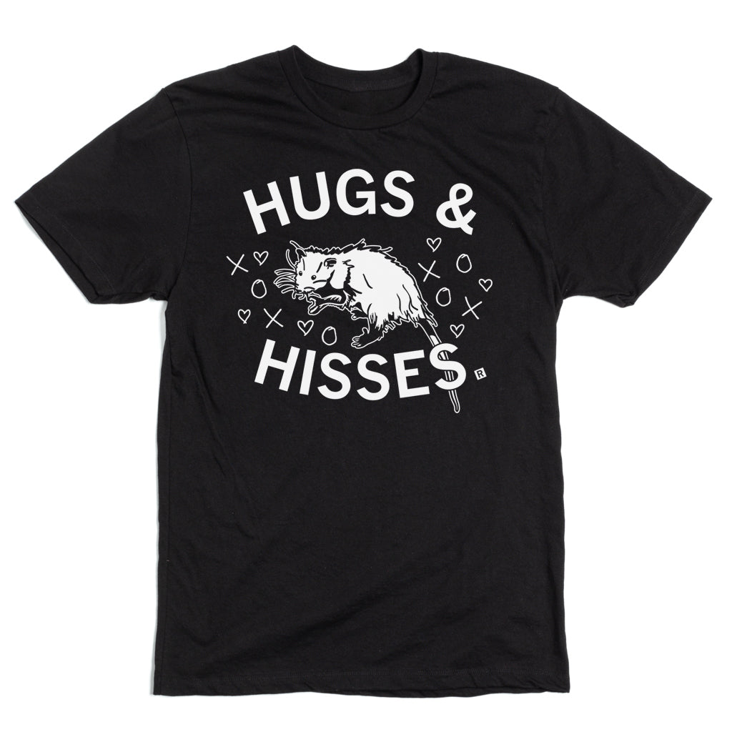 Black, union-made t-shirt featuring an illustration of an opossum surrounded by hearts and XOXO symbols, with the white text HUGS & HISSES above and below the animal.