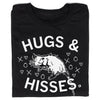 Union made black t-shirt featuring an illustration of an opossum surrounded by hearts, Xs, and Os, with the text HUGS & HISSES.