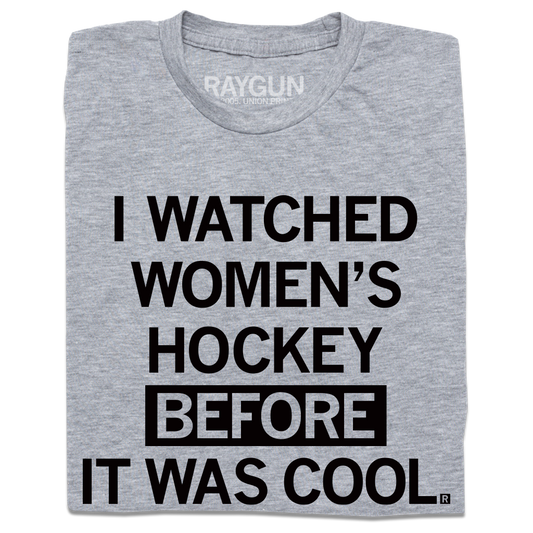 A folded heather grey t-shirt with centered black in text that reads "I Watched Women's Hockey Before It Was Cool"