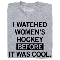 A folded heather grey t-shirt with centered black in text that reads "I Watched Women's Hockey Before It Was Cool"