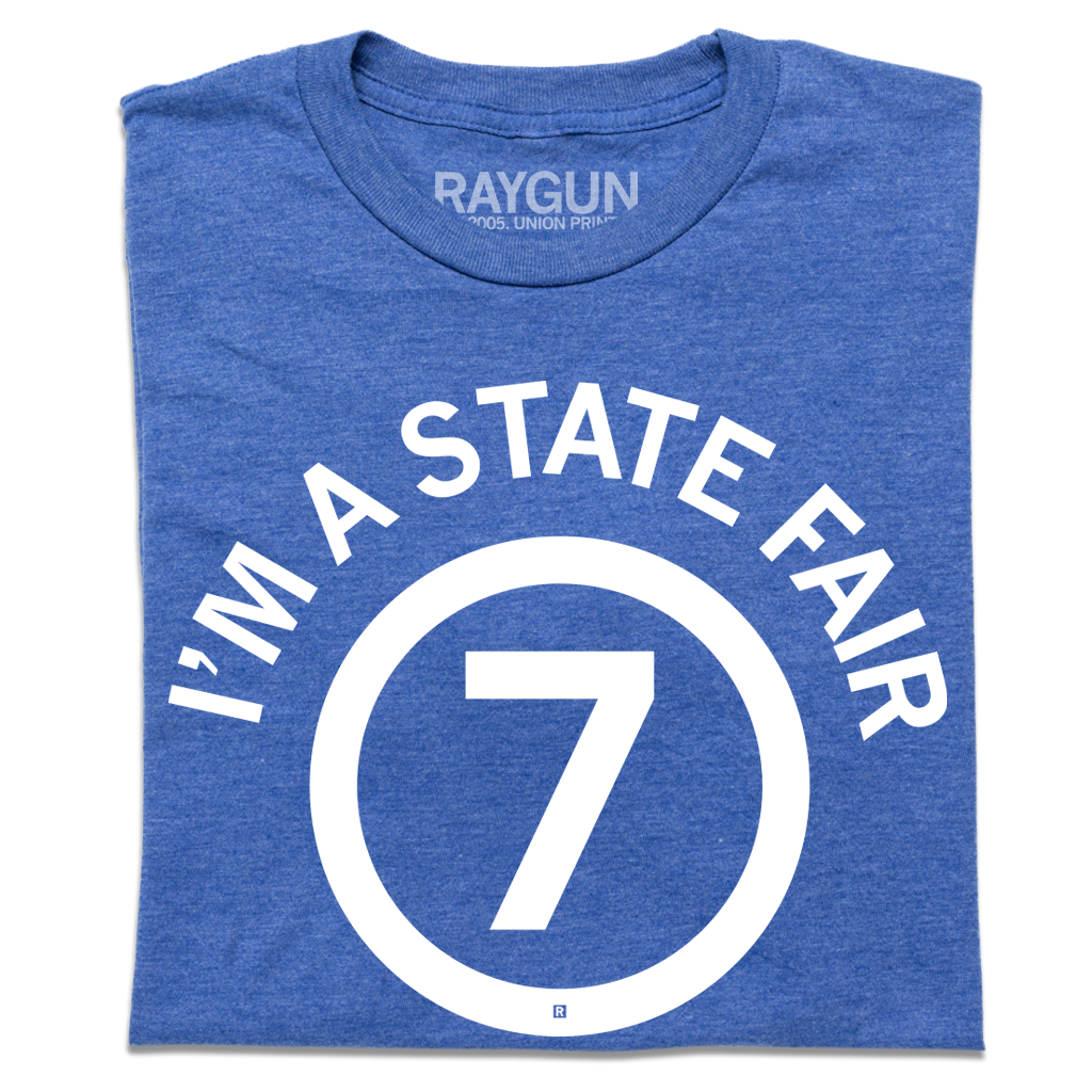 Heather royal blue t-shirt featuring the white text IM A STATE FAIR in a circle around the number 7.
