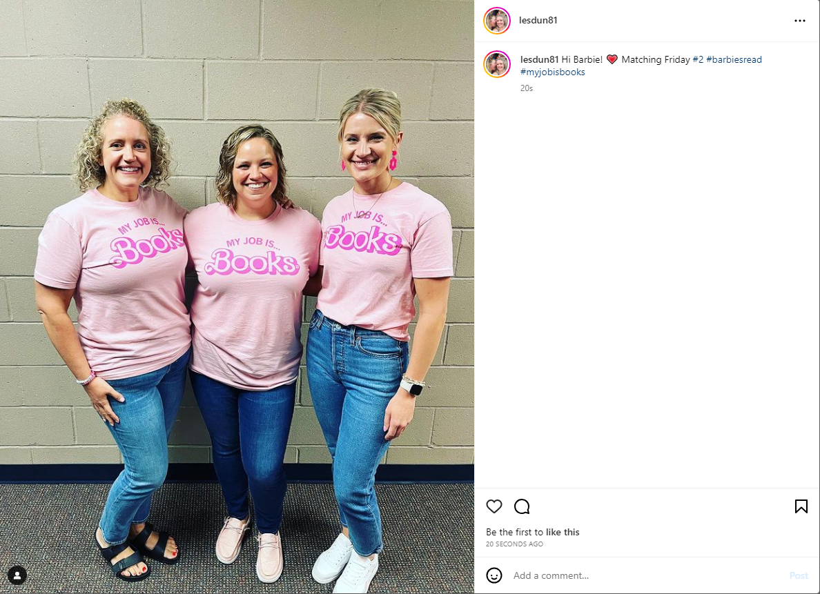 Three women stand in a row wearing blue jeans and union made, matching pink t-shirts that read My job is... books in a Barbie-inspired font.