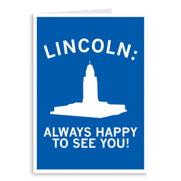 RAYGUN greeting card with a blue background featuring a white silhouette of the Nebraska State Capitol building and the text LINCOLN: ALWAYS HAPPY TO SEE YOU!.