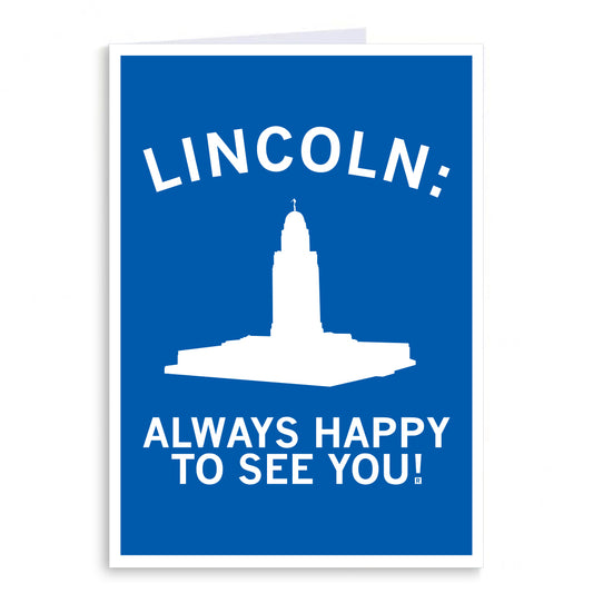 RAYGUN greeting card with a blue background featuring a white silhouette of the Nebraska State Capitol building and the text LINCOLN: ALWAYS HAPPY TO SEE YOU!.