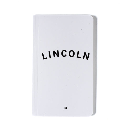 White notebook with the word LINCOLN printed in bold black screen print on the cover.