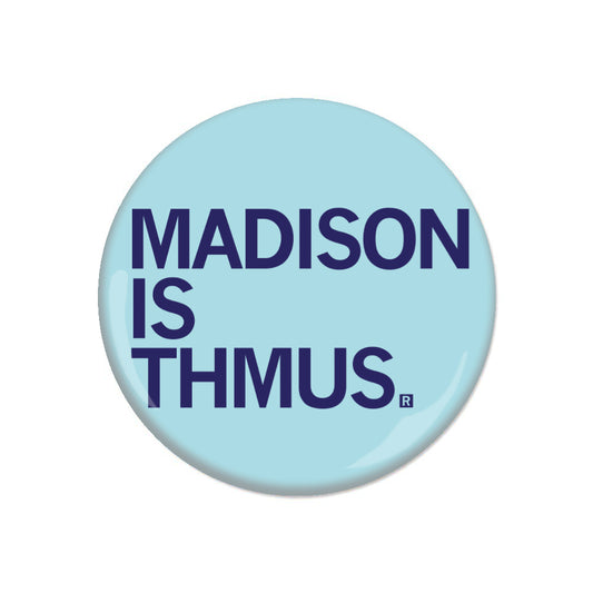 A light blue RAYGUN metal button with the text MADISON IS THMUS in dark blue capital letters.