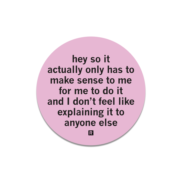 A pink circle sticker with black text that says, 
