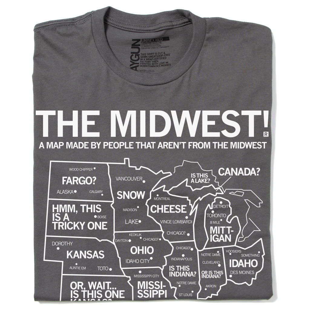 A folded grey t-shirt with white ink depicting a satirical map of the Midwest with text above that reads "The Midwest! A Map Made By People That Aren't From The Midwest"