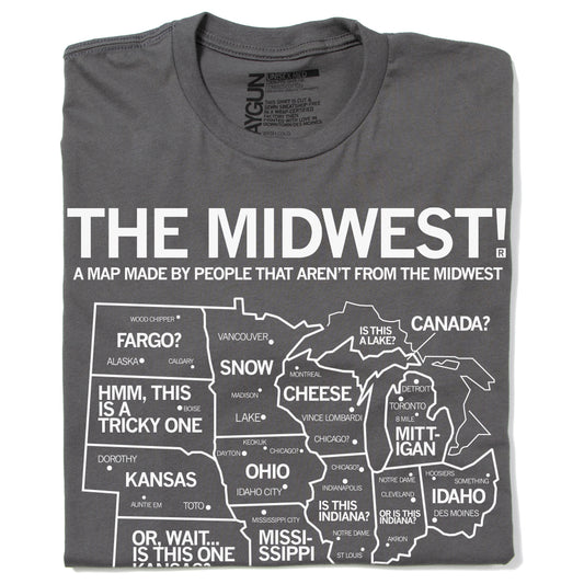 A folded grey t-shirt with white ink depicting a satirical map of the Midwest with text above that reads "The Midwest! A Map Made By People That Aren't From The Midwest"