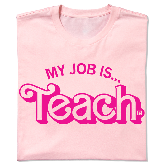 A folded light pink t-shirt with hot pink ink text that says, "My Job Is...Teach" with "Books" being in Barbie font.