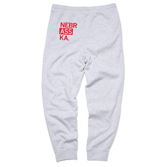 Heather gray Nebraska sweatpants with the text NEBR ASS KA. printed in red on the upper back.