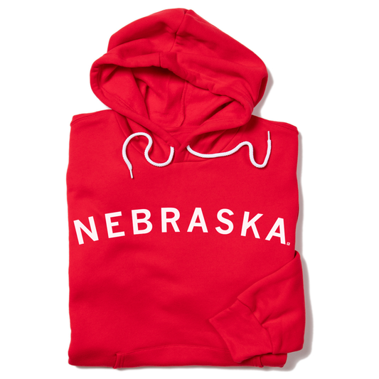 Union-made red pullover hoodie with NEBRASKA printed in white letters across the chest and white drawstrings.