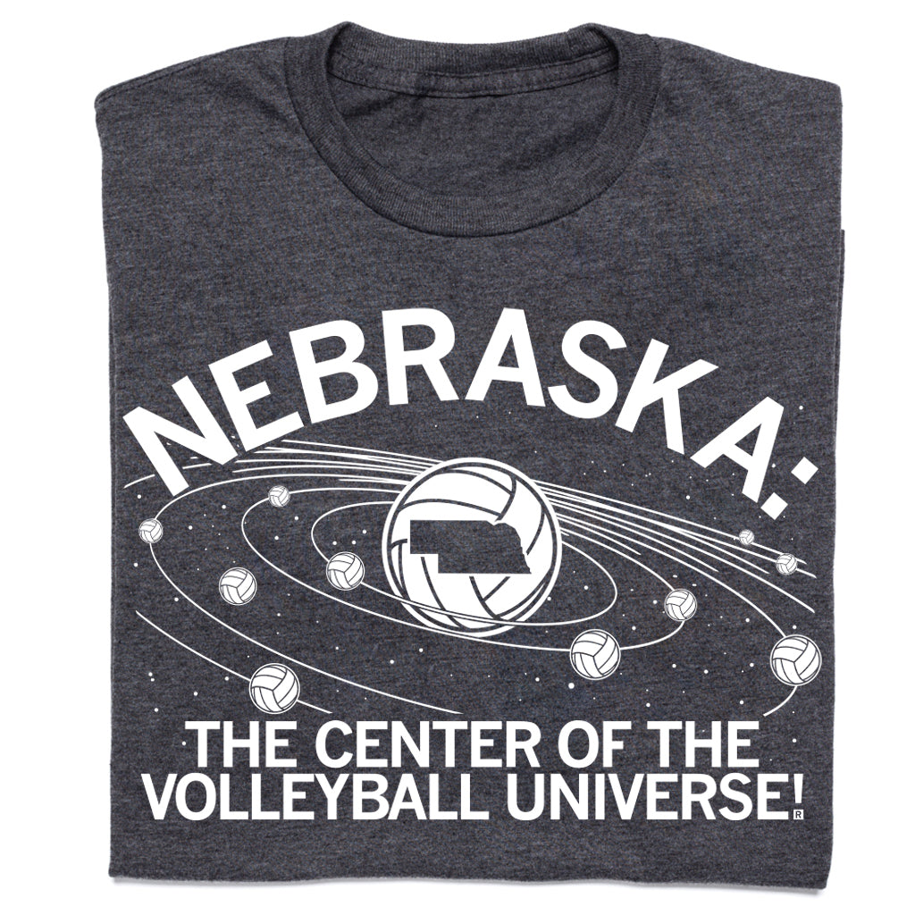 Charcoal T-shirt featuring a volleyball graphic with the state of Nebraska at the center of planetary rings, surrounded by smaller volleyballs and the text NEBRASKA: THE CENTER OF THE VOLLEYBALL UNIVERSE!.