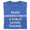 A heather royal blue t-shirt whit centered white text that says, "Never Underestimate a Public School Teacher" in all caps.