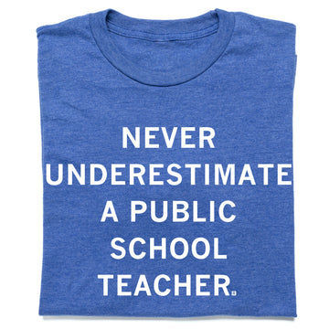 A heather royal blue t-shirt whit centered white text that says, "Never Underestimate a Public School Teacher" in all caps.