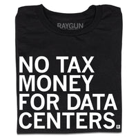 A folded black t-shirt with white ink text that reads "No tax money for data centers."