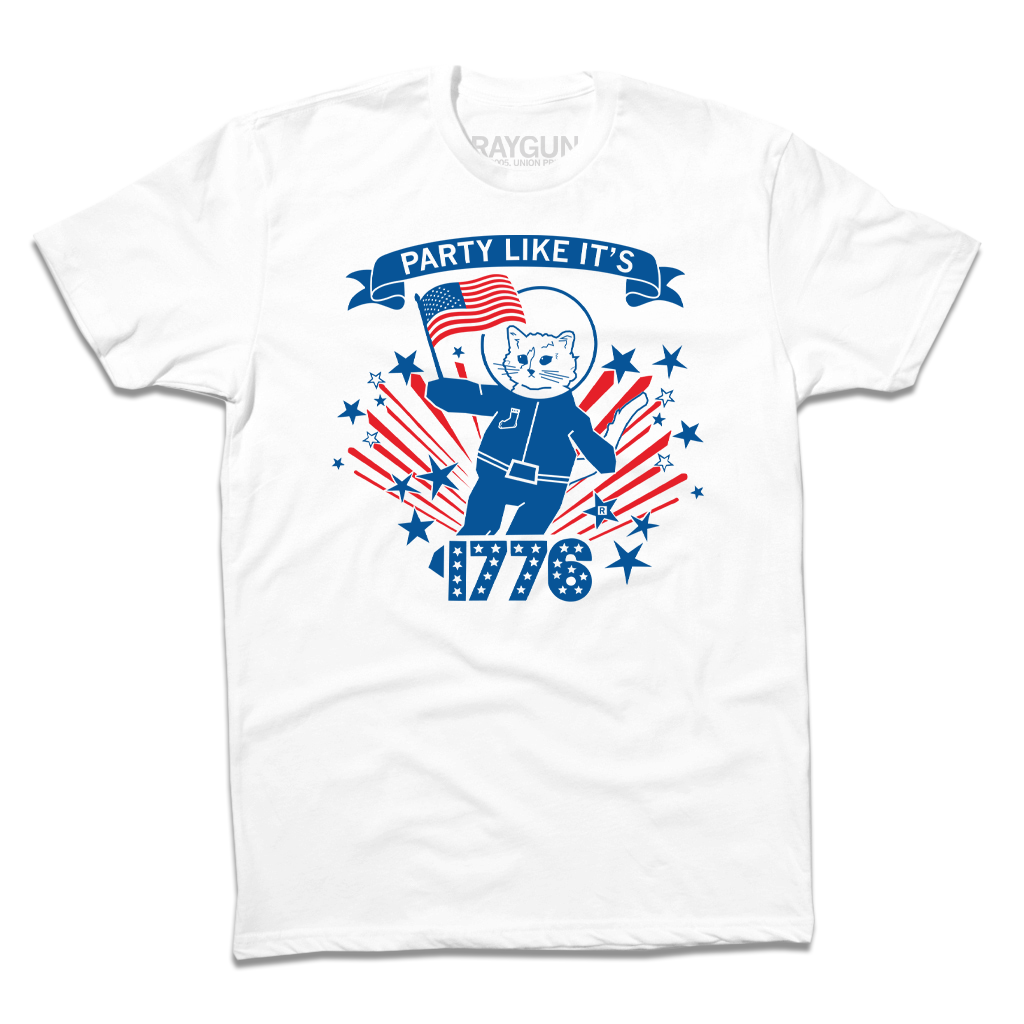White patriotic t-shirt featuring a cat in an astronaut suit holding an American flag, with the text PARTY LIKE ITS 1776 and red and blue star accents.