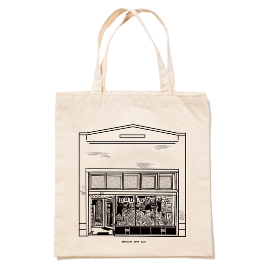 Natural canvas tote bag made in the USA featuring a black line drawing of the Pauls Books storefront with the text MADISON. 1954-2025 printed at the bottom.