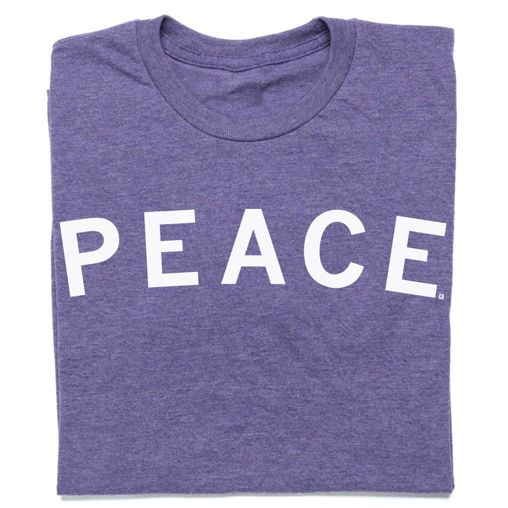Folded heather purple t-shirt with the word PEACE printed in white capital letters.