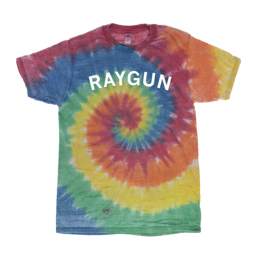 Short-sleeved rainbow tie-dye t-shirt with a spiral pattern in red, yellow, green, and blue, featuring the word RAYGUN printed in white across the chest.