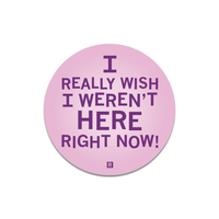 A pink circular sticker with purple text that says, "I really wish I weren't here right now!"