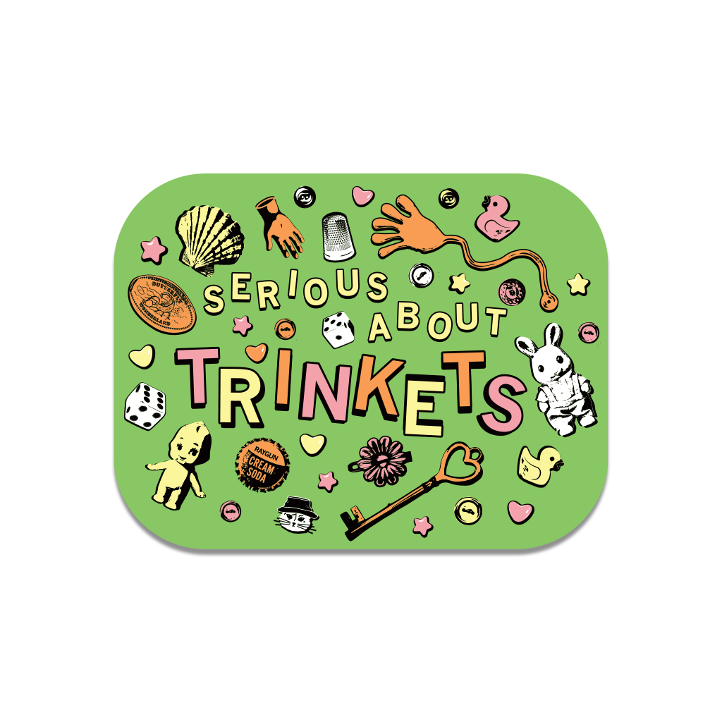 A RAYGUN die-cut vinyl sticker with the text SERIOUS ABOUT TRINKETS surrounded by various small objects including a seashell, dice, a thimble, a rubber duck, a skeleton hand, a key, and a small doll.