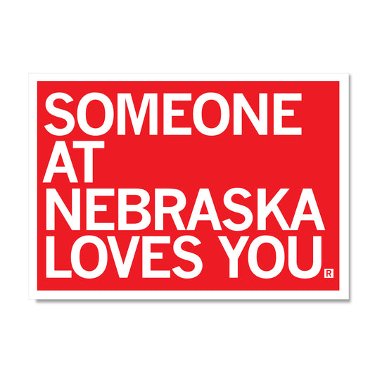 A red rectangular RAYGUN sign with white text that reads, SOMEONE AT NEBRASKA LOVES YOU.