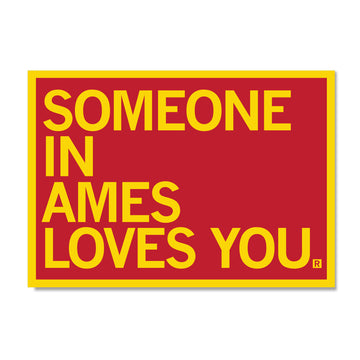 A red rectangular RAYGUN sign with a yellow border and the yellow text SOMEONE IN AMES LOVES YOU.