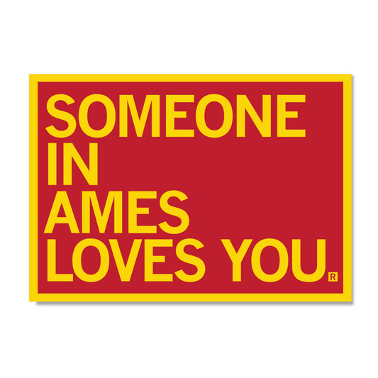 A red rectangular RAYGUN sign with a yellow border and the yellow text SOMEONE IN AMES LOVES YOU.