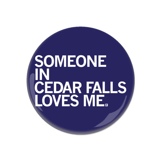A dark blue, circular RAYGUN metal button that reads, SOMEONE IN CEDAR FALLS LOVES ME.