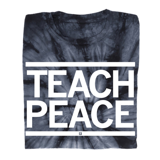 Folded black and grey union-made tie-dye t-shirt with the text TEACH PEACE printed in large white capital letters.