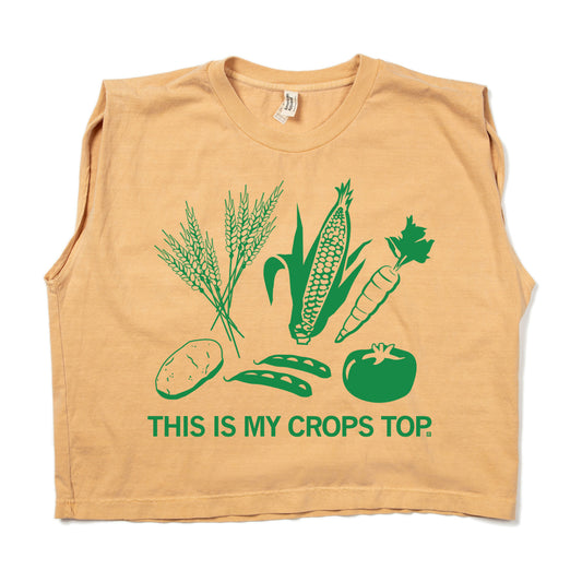 Tan sleeveless cropped top featuring a green graphic of wheat, corn, a carrot, a potato, pea pods, and a tomato with the text THIS IS MY CROPS TOP on this heavyweight t-shirt.