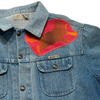 Vintage light blue denim jacket featuring an AVANTO metal badge and an irregular RAYGUN-style patch of a stylized animal in shades of red and orange on the upper chest.