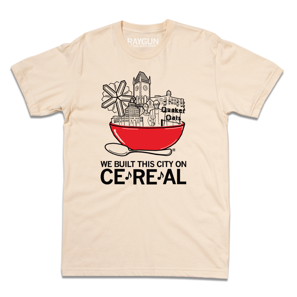 Cream-colored RAYGUN t-shirt with a graphic of a red bowl of cereal containing a city skyline and Quaker Oats, captioned WE BUILT THIS CITY ON CE*RE*AL.