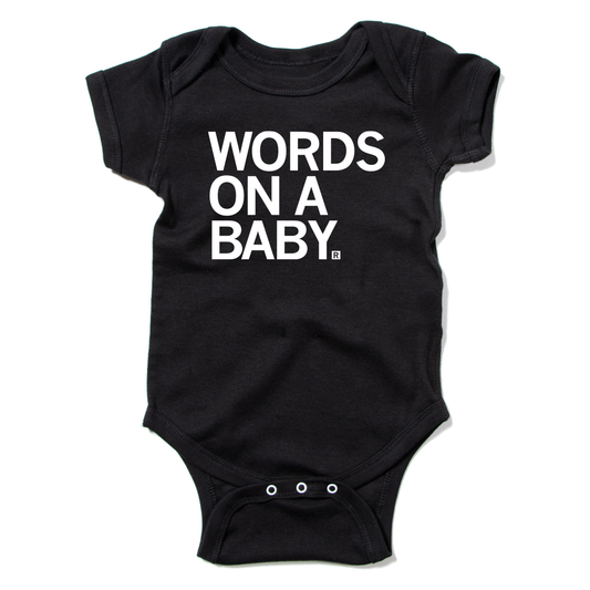 Black baby onesie with the text WORDS ON A BABY printed in white on the chest.